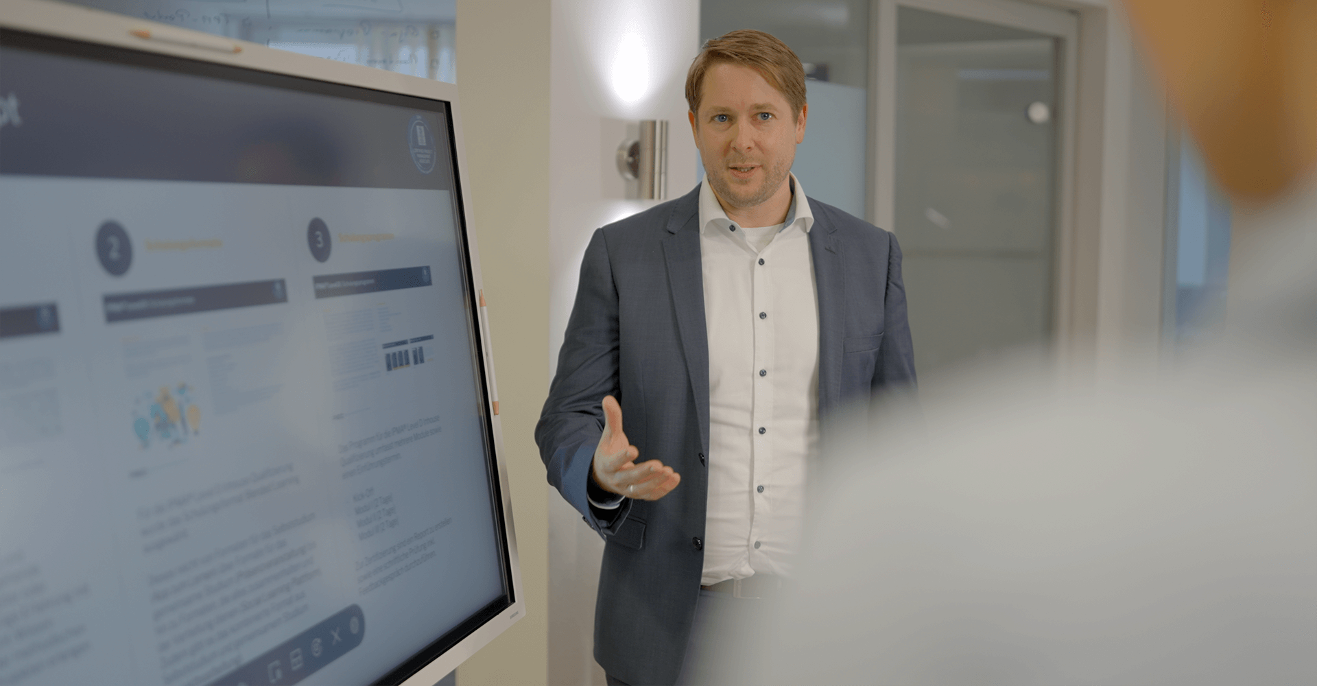 pec-portfolio-prozessmanagement Markus Hegeler stellt einem Mitarbeiter die Vorteile des Prozessmanagements mithilfe einer Präsentation vor.